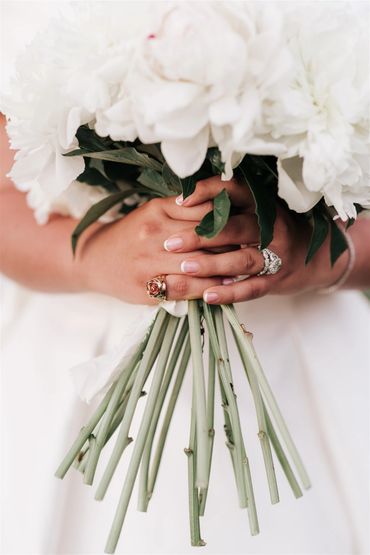Close up of bride's hands holding her white bouquet