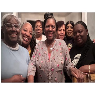 Group of smiling women gathered indoors.