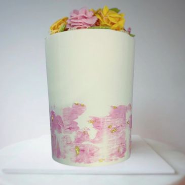 Double barrel 6 inch vanilla cake with pink and yellow buttercream roses on top, gold foil at base