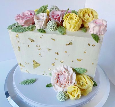 Flower decorated buttercream special events cake for half birthday with edible gold accents