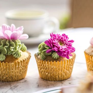Three Buttercream flower cupcakes in gold foil cupcake wrappers for special occasion