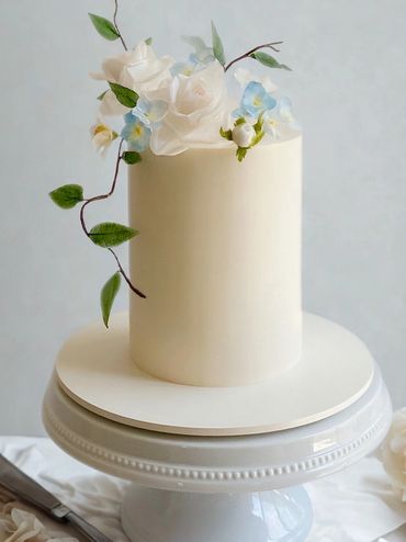 Elegant tall cake with buttercream frosting and edible flowers