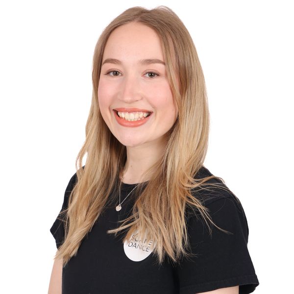 Smiling young woman with long blonde hair wearing a black shirt.