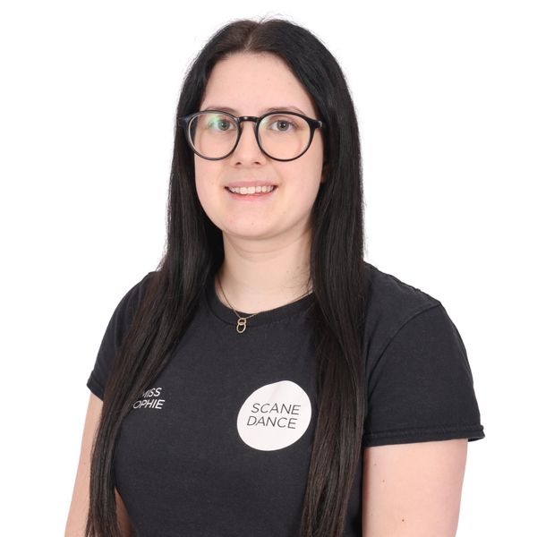 Young woman with long dark hair and glasses wearing a black Scane Dance t-shirt.