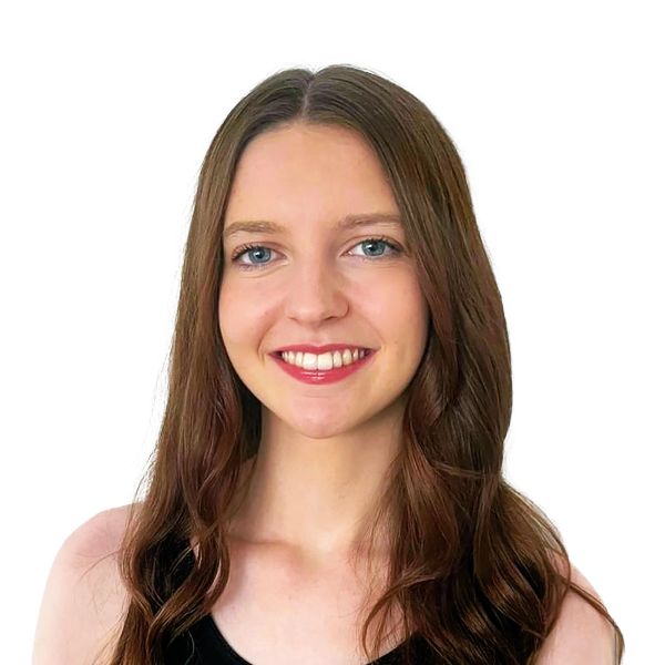 Young woman with long brown hair smiling against a white background.