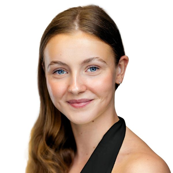 Young woman with blue eyes and brown hair smiling gently at the camera.