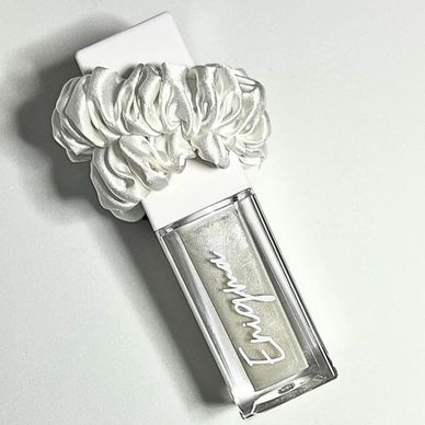 White lip oil in white bottle
Silk scrunchie