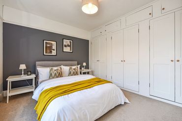 Bedroom with sash window and built-in wardrobes