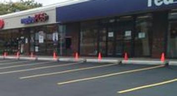 Freshly painted parking lot striping services outside retail storefronts.