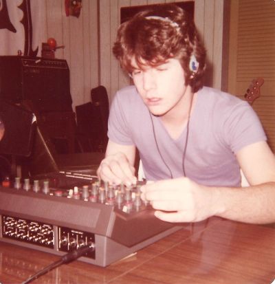 Young man adjusting audio mixer with headphones.