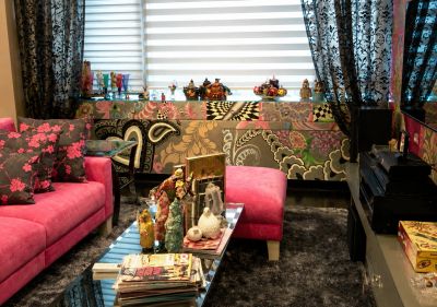 Cozy living room with pink sofa and colorful cushions.