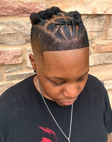 Man with stylish twisted top knots and sharp faded sides hairstyle.