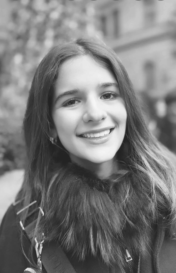 Young woman smiling with a fur collar in black and white.