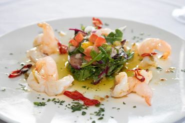 Shrimp salad with mixed greens and diced vegetables drizzled with olive oil.
