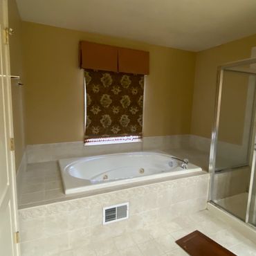 Bathroom jet-tub before tile and grout and shower glass removal process began.