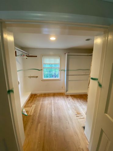 Large walk in closet before demo & removal of clothes racks and clothes storage built into walls.