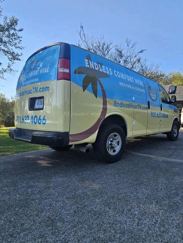 A yellow and blue Endless Comfort HVAC van parked outdoors on a sunny day.