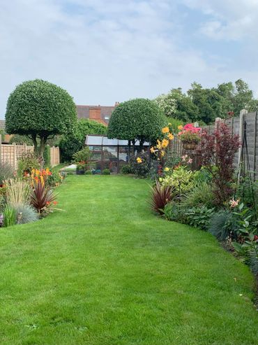 Relaxing well maintained garden with cut lawns and scented and colourful flowers