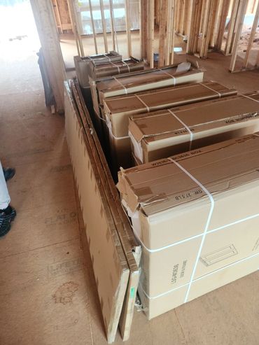Stacked cardboard boxes and panels inside a building under construction.
