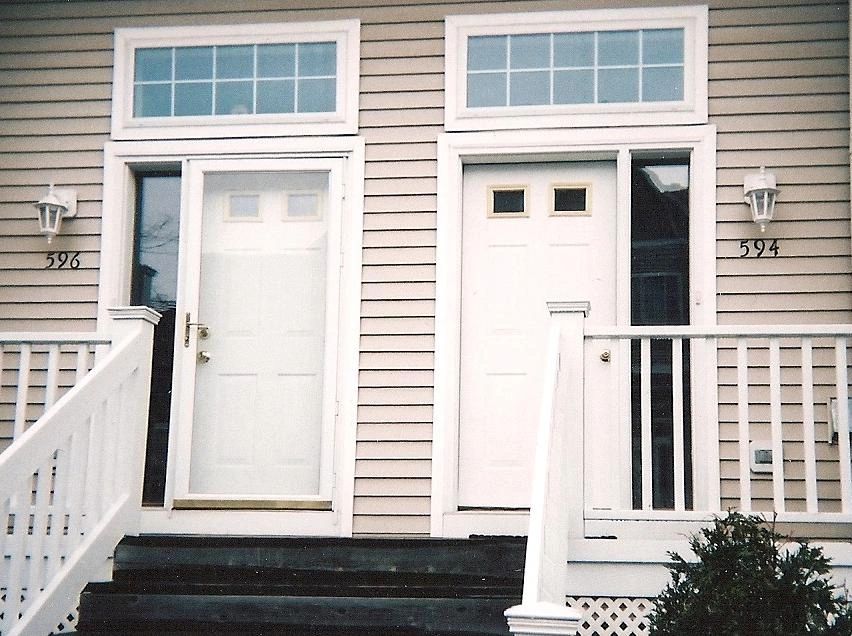 Two adjacent white front doors with house numbers 596 and 594.
