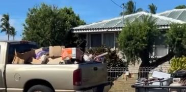 Pickup truck loaded with boxes parked outside a house.