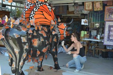 The artist Deprise working on Moo Monarch for Cow Parade SLO for the city of Pismo Beach.