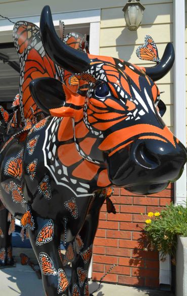 The face of a butterfly cow, Moo Monarch with butterfly lashes by artist Deprise for Cow Parade SLO
