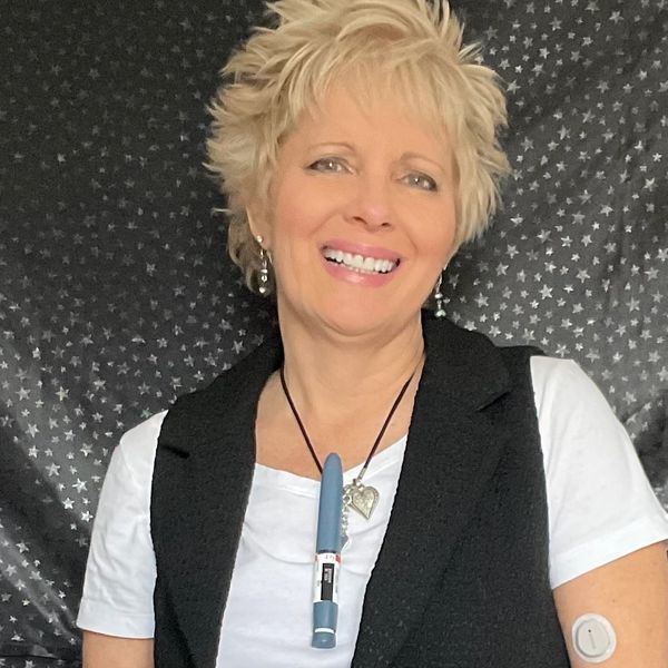 Glucose Goddess head shot smiling bio picture wearing Insulin pen as Necklace