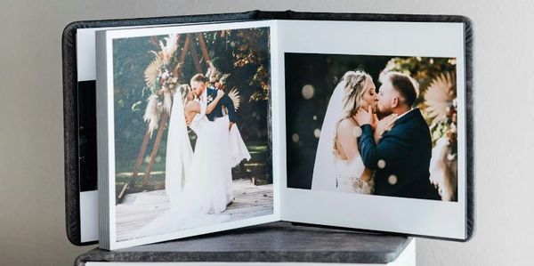 Wedding photo album open to pictures of a bride and groom kissing and embracing.