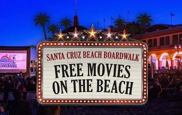 Sign announcing free movies on the beach at Santa Cruz Beach Boardwalk at night.
