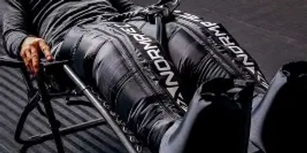 Person reclining on a chair wearing black pants with 'WONDERLAND' text.