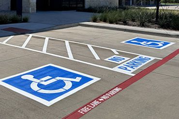 Handicap parking spaces with clear blue and white markings in a parking lot.