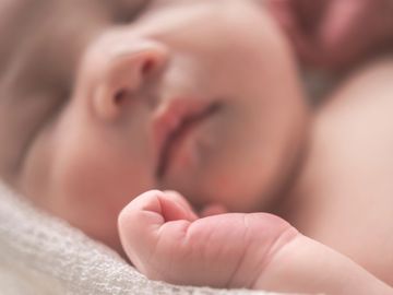 newborn baby sleeping on a blanket