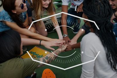 Group of friends joining hands in a circle.