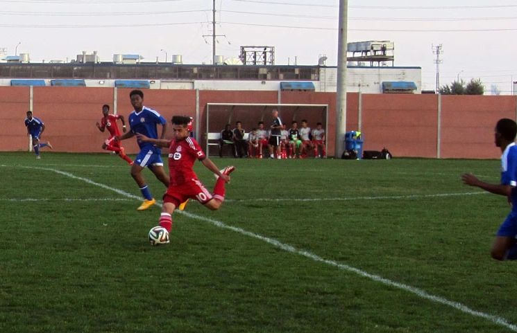 Youth playing soccer in a field in Toronto's Ward 10, Spadina-Fort York.