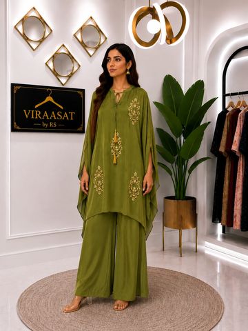 Woman in stylish olive green ethnic outfit posing indoors.