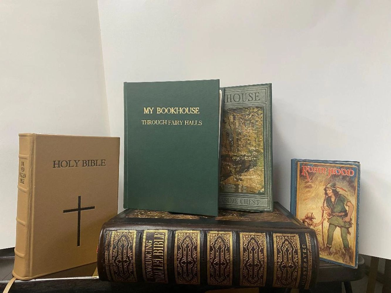 A collection of vintage books including Bibles and classic stories like Robin Hood.