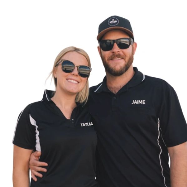 Couple wearing matching black shirts with names Taylia and Jaime, smiling and wearing sunglasses.