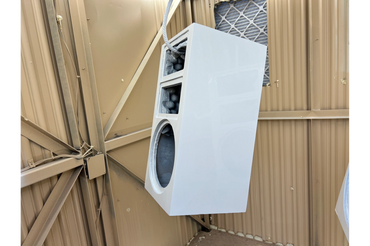 White speaker cabinet mounted on a beige metal ceiling structure.