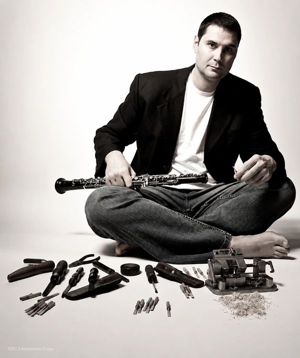 Man sitting with a clarinet and disassembled parts spread out before him.