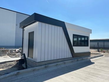 A large bespoke gatehouse at a distribution warehouse, matching colour of building on site.
