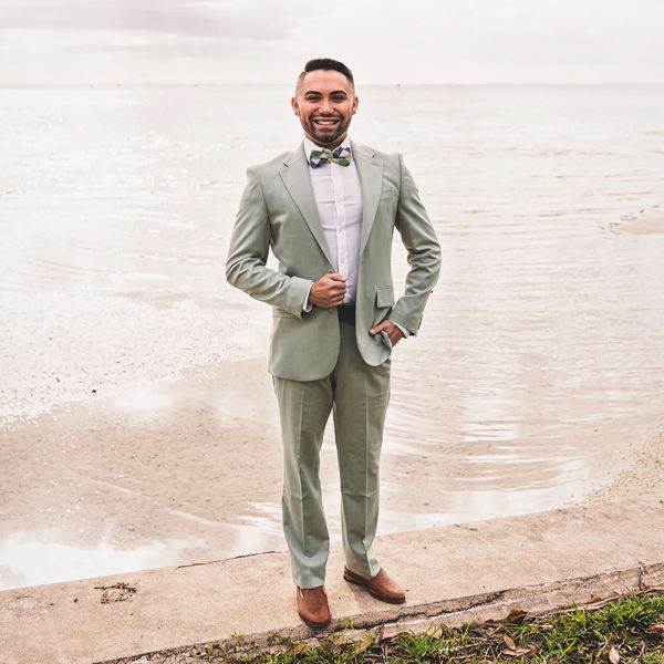 A man, Dr. Huffman, in a light green suit with a bow tie smiling by the water.