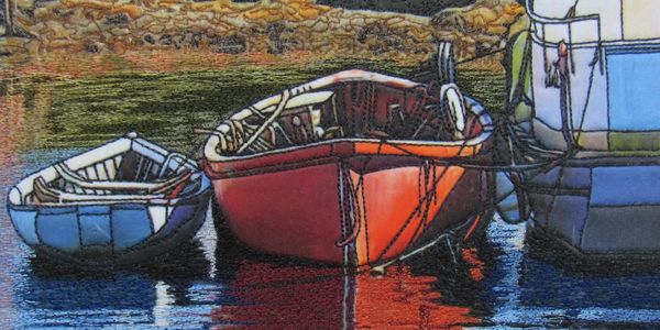 Two small boats and one larger boat tied up on calm water.
