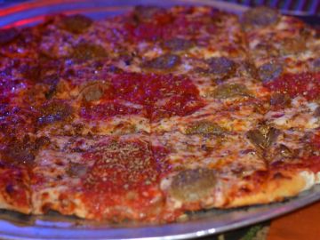 A close-up of a pepperoni pizza with some mushrooms.
