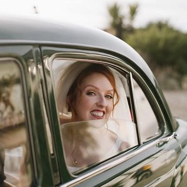 Beautiful Bride smiling in wedding car