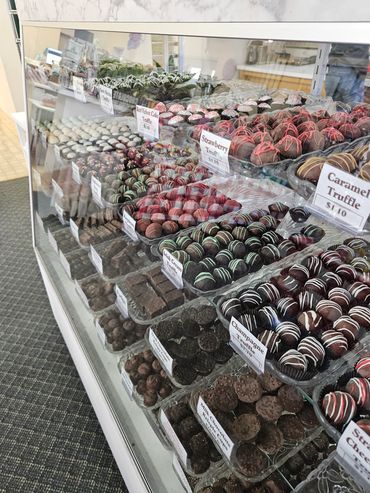 Display case filled with assorted chocolate truffles and candies.