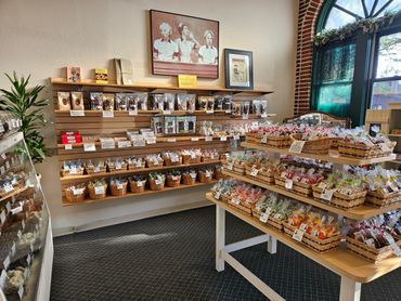 Interior of a candy store with neatly arranged baskets of sweets and chocolates.