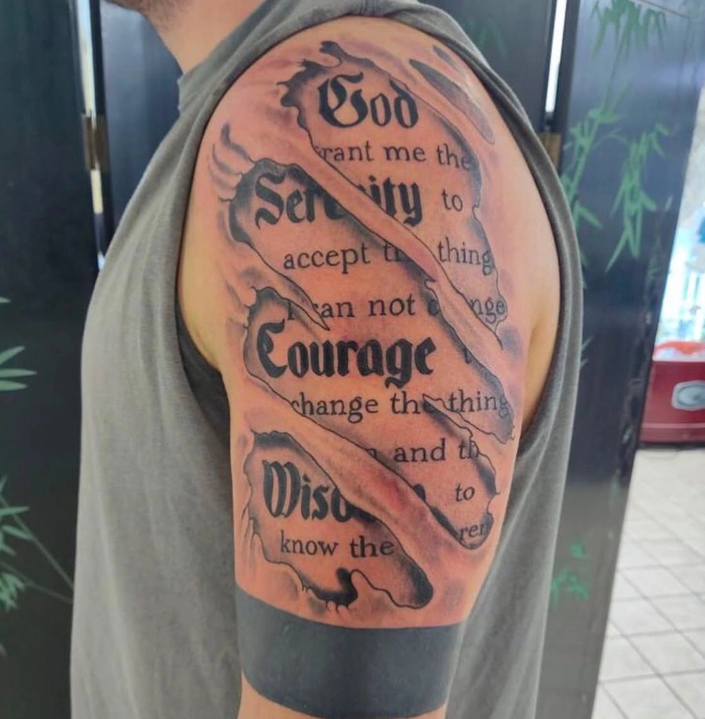 Tattoo of the Serenity Prayer with a torn skin design.