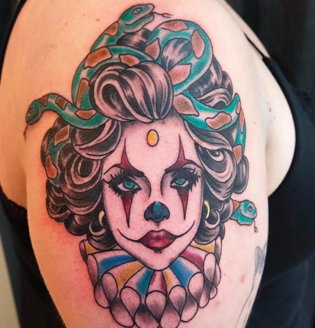 Tattoo of a clown woman with snakes in her hair.