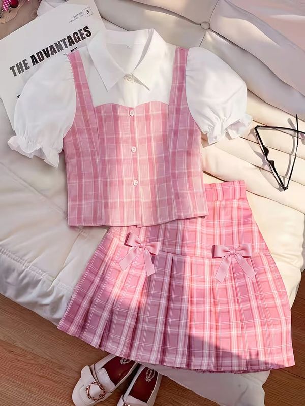 Pink plaid outfit with white puff sleeve blouse and bows.